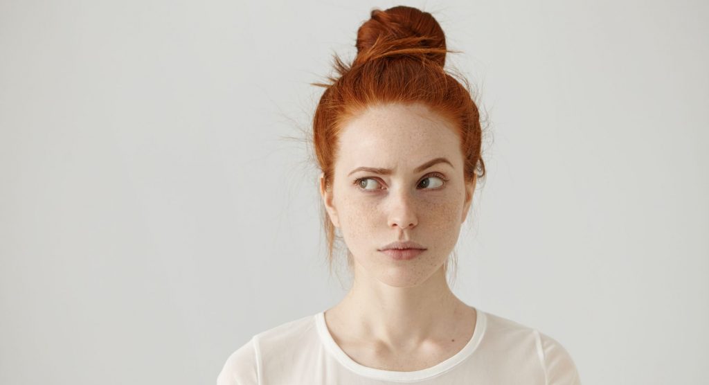 Red-headed woman raising an eyebrow