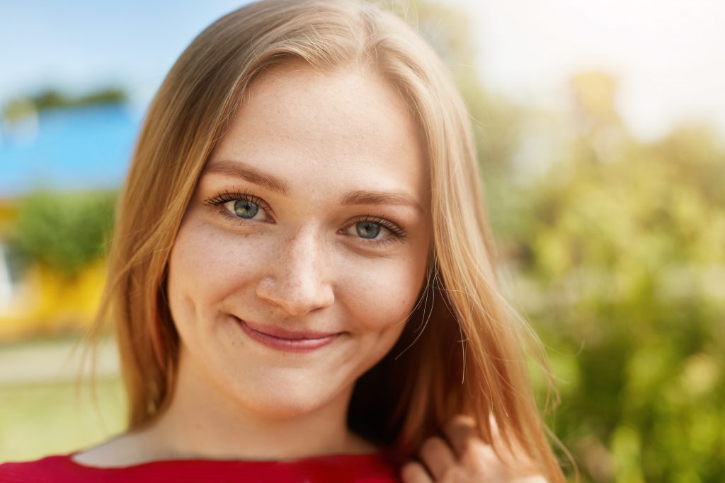 Girl with dimples in a green field